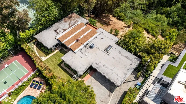 an aerial view of a house with a yard and swimming pool