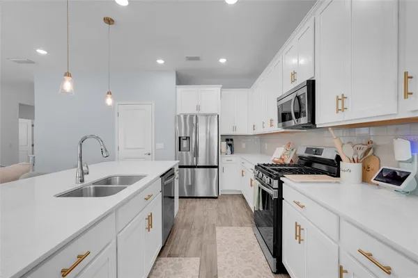 a kitchen with stainless steel appliances granite countertop a sink stove and refrigerator