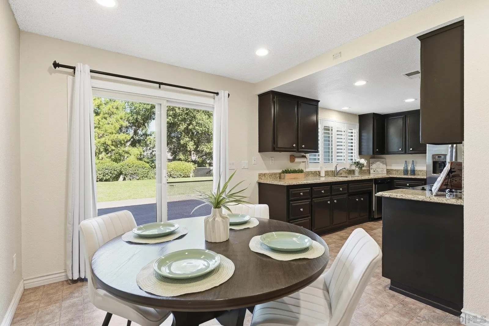 16120 Poderio Court Ramona, CA 92065 - Photo 19 of 38 a kitchen with a stove a refrigerator a sink a dining table and chairs
