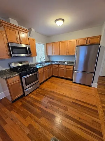 a kitchen with stainless steel appliances wooden cabinets and a stove top oven