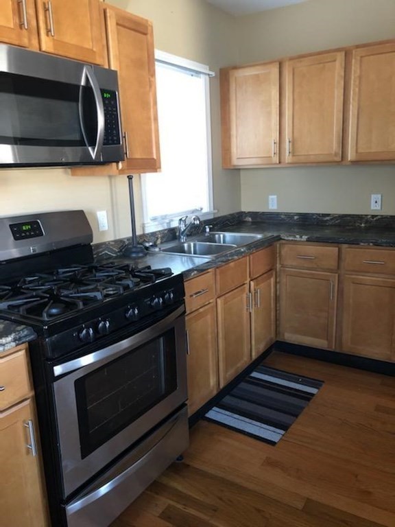 1066 Bedford Street, Unit 1 Fall River, MA 02723 - Photo 2 of 7 a kitchen with granite countertop a stove and a sink