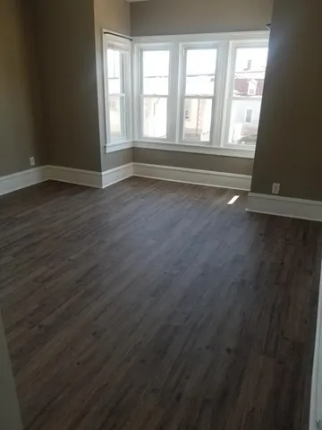 a view of room with window and wooden floor