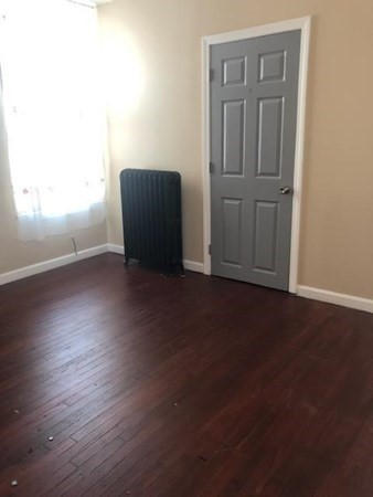 1066 Bedford Street, Unit 1 Fall River, MA 02723 - Photo 4 of 7 an empty room with wooden floor closet and windows