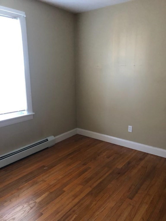 1066 Bedford Street, Unit 1 Fall River, MA 02723 - Photo 5 of 7 a view of an empty room with wooden floor and a window