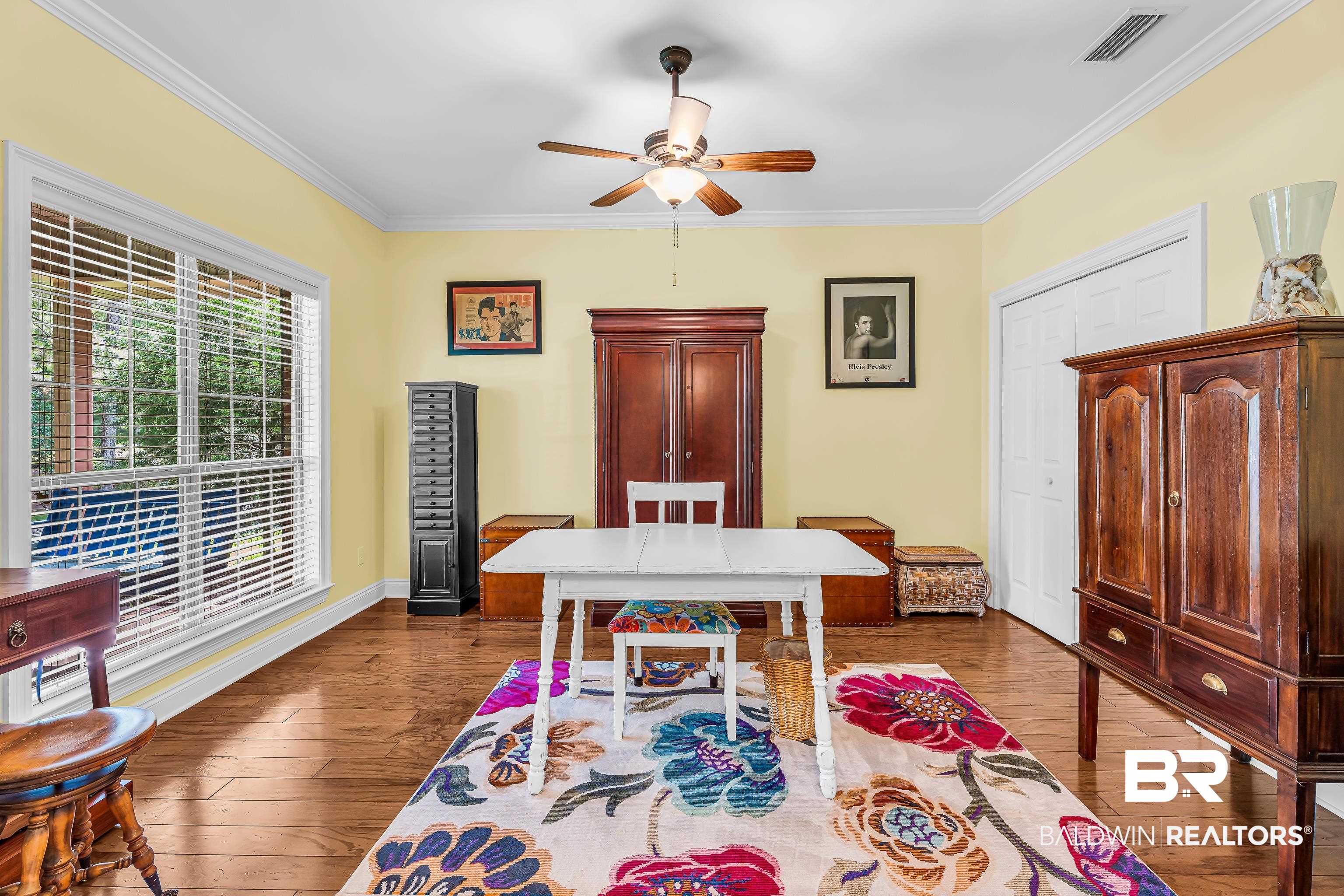7014 Blakeley Road Daphne, AL 36527 - Photo 21 of 45 Room featuring light yellow walls, crown molding, and wood-finish flooring