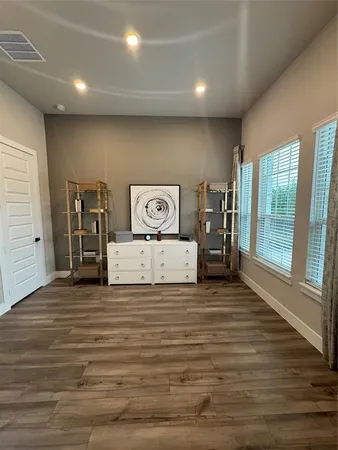 a view of a livingroom with an empty space & a window