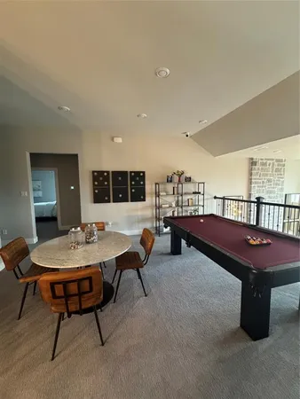 a living room with furniture a table and a pool table