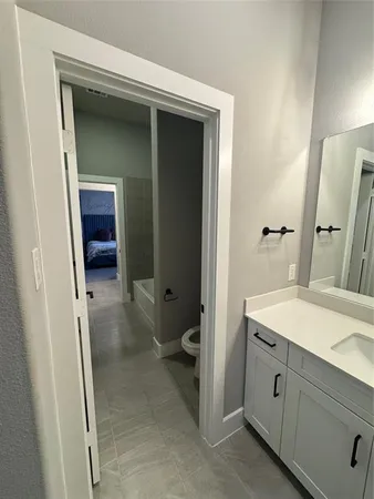a spacious bathroom with a granite countertop sink and a mirror