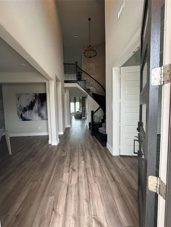 a view of entryway and hall with wooden floor