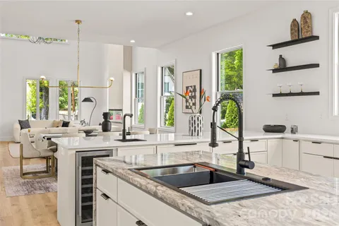 a kitchen with granite countertop a stove a sink a refrigerator and a stove