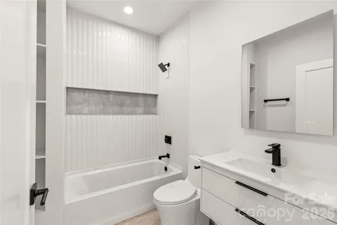 a bathroom with a tub sink and mirror