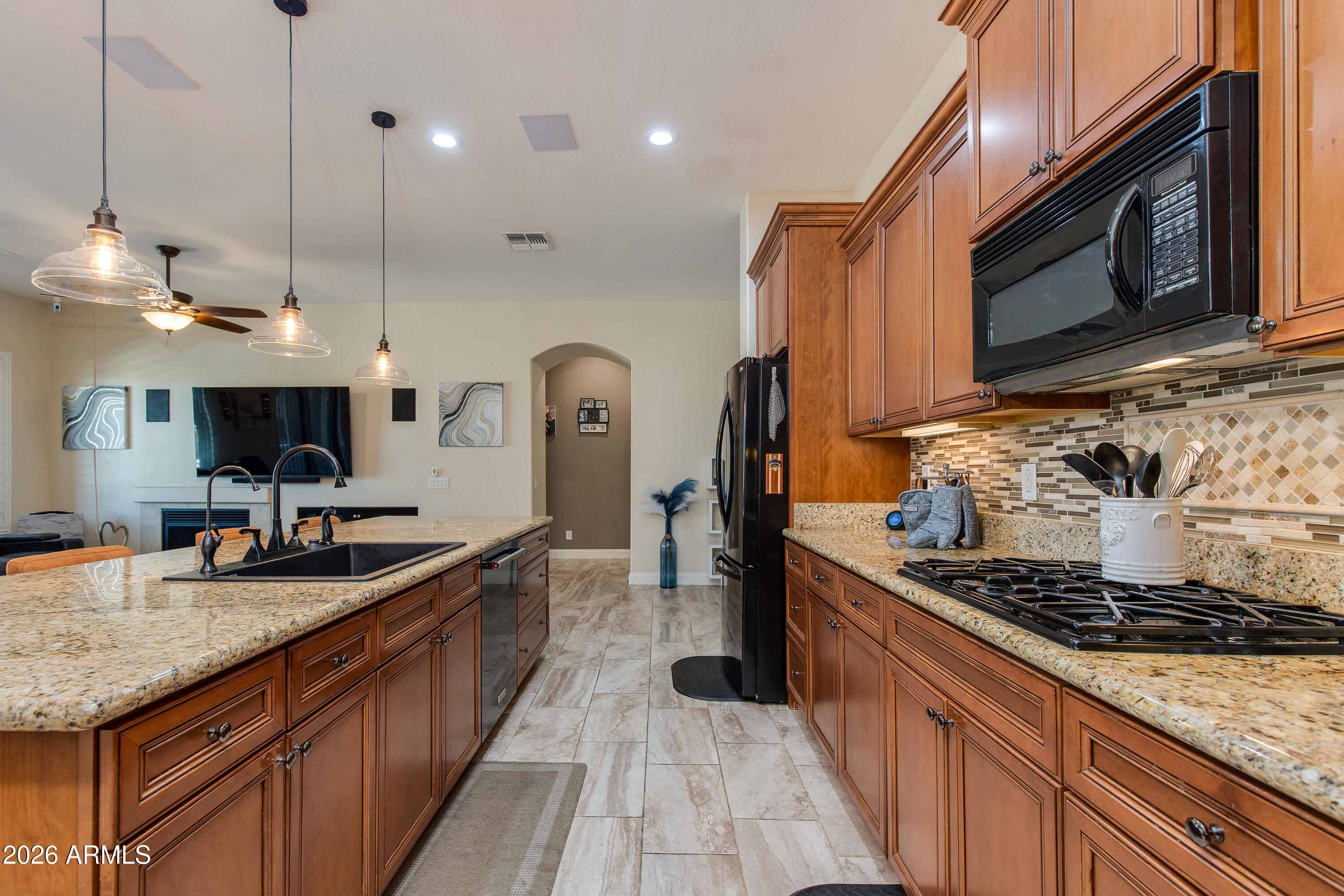 7718 North 84th Lane Glendale, AZ 85305 - Photo 17 of 82 a kitchen with stainless steel appliances granite countertop a sink a stove and a wooden cabinets