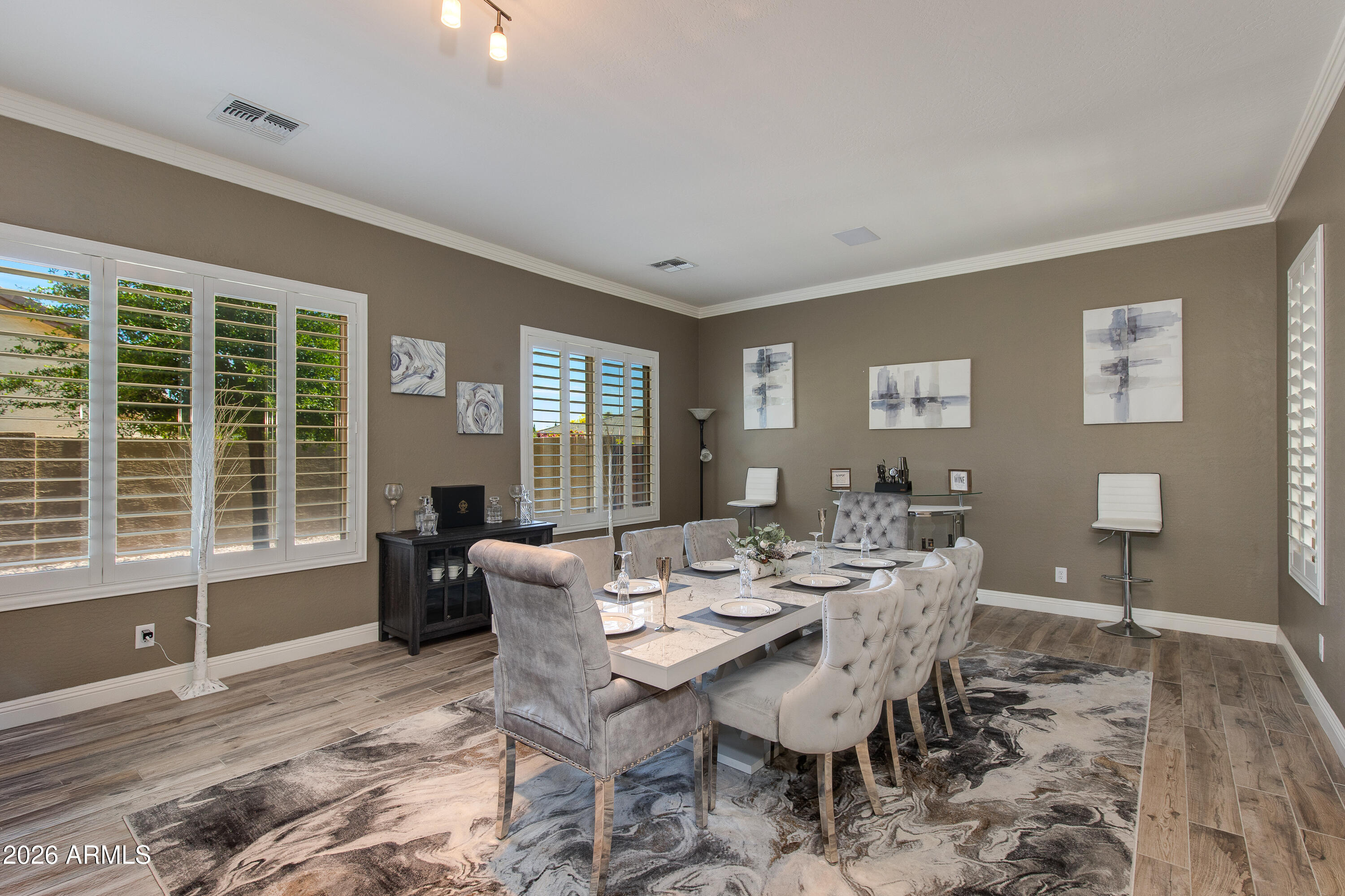 7718 North 84th Lane Glendale, AZ 85305 - Photo 6 of 82 a view of a dining room with furniture large windows and wooden floor