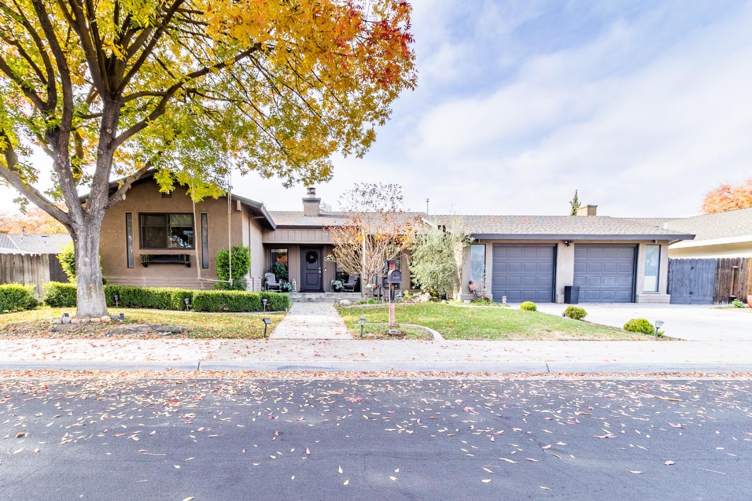 a front view of a house with a yard and trees