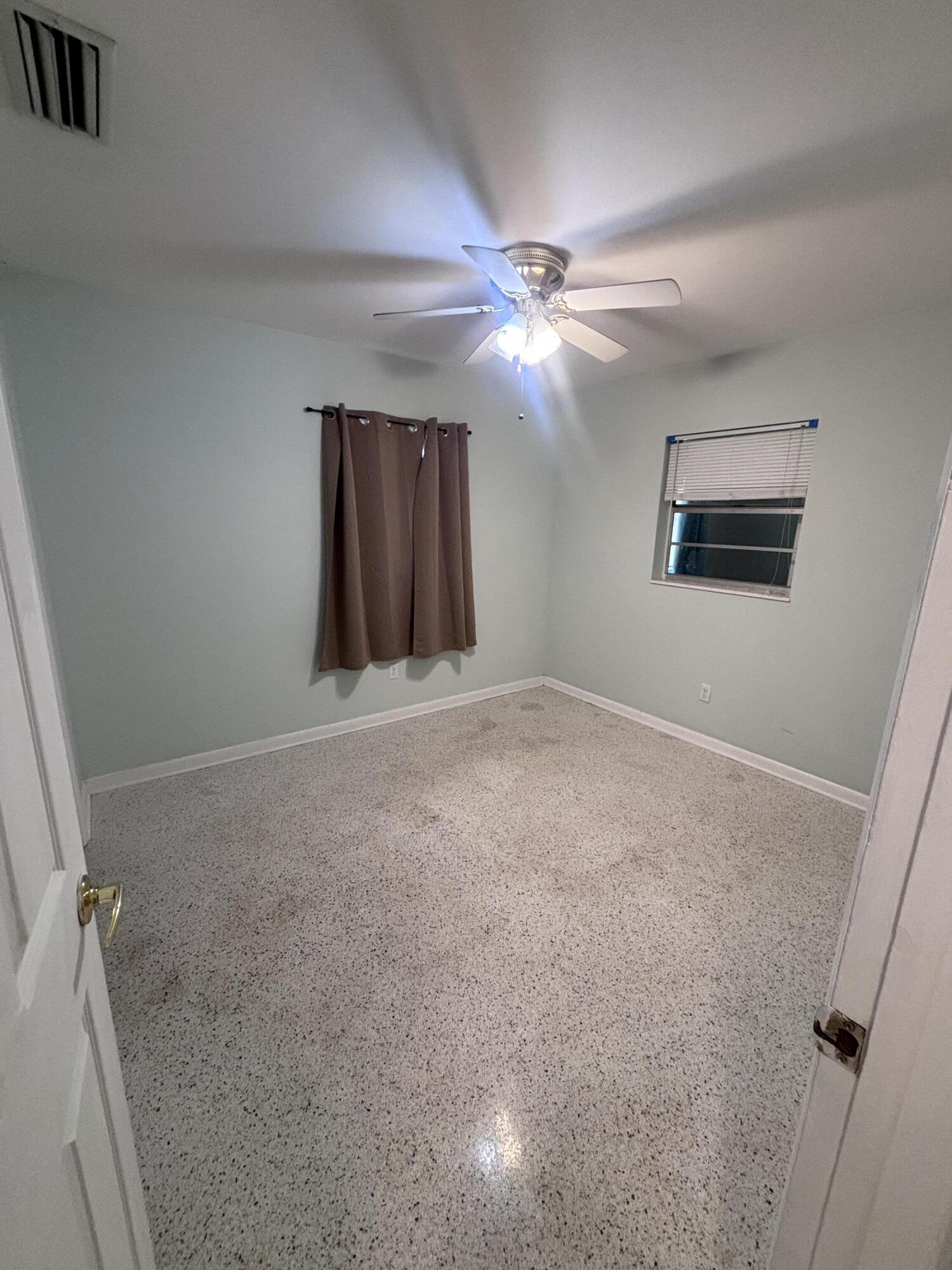 202 Balboa Street, Unit A Fort Pierce, FL 34949 - Photo 6 of 10 a view of a livingroom with a ceiling fan and window