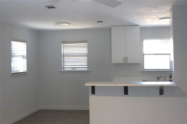 a kitchen with a white cabinets appliances and a window