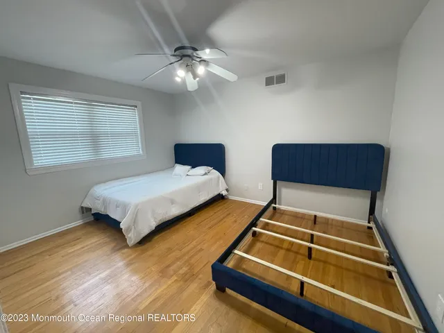 a bedroom with two beds and lamp