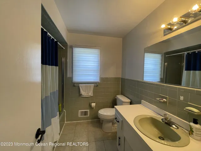 a bathroom with a sink a toilet and a mirror