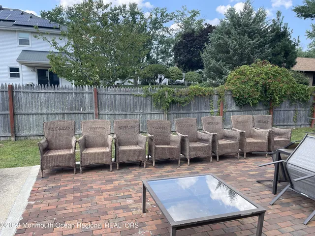 a view of a patio with couches table and chairs with wooden fence