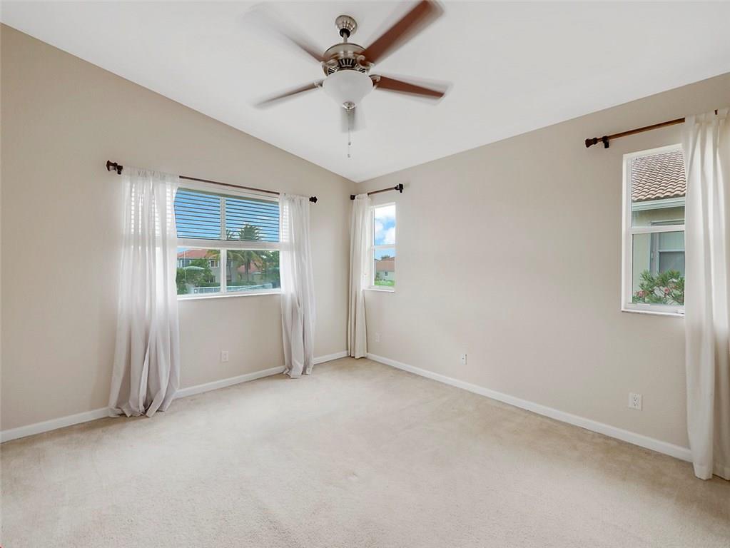 3075 Laurel Ridge Circle Riviera Beach, FL 33404 - Photo 4 of 12 an empty room with windows and fan