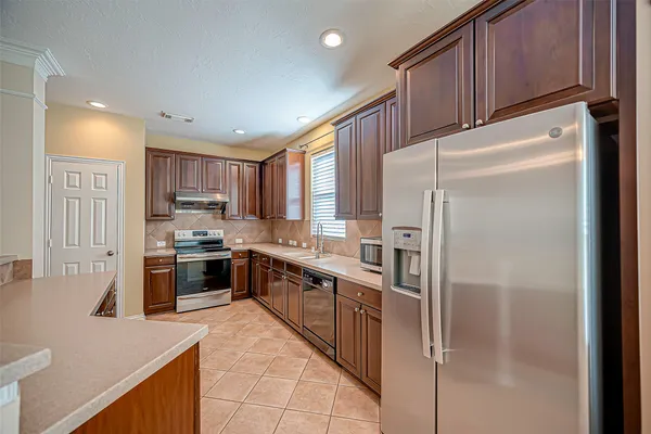 a open kitchen with stainless steel appliances granite countertop a refrigerator stove top oven and sink