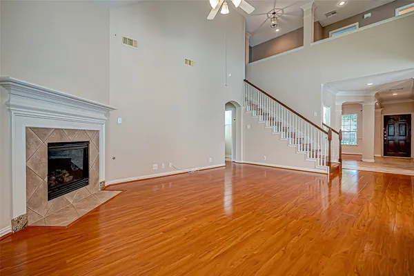 a view of an empty room wooden floor and a fireplace