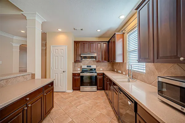 a kitchen with stainless steel appliances granite countertop sink stove refrigerator and cabinets