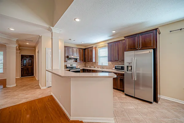 a kitchen with stainless steel appliances granite countertop a refrigerator a stove top oven a sink and dishwasher
