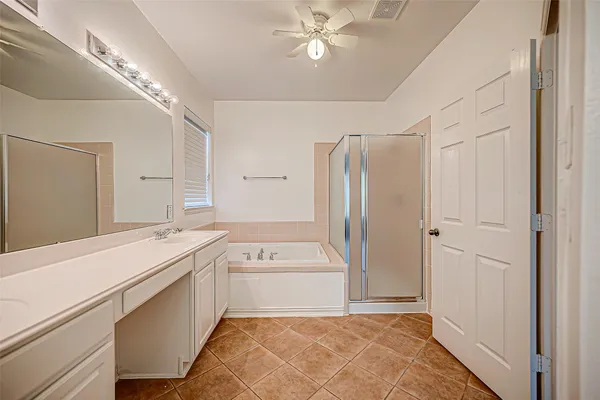 a bathroom with a tub sink shower and a mirror