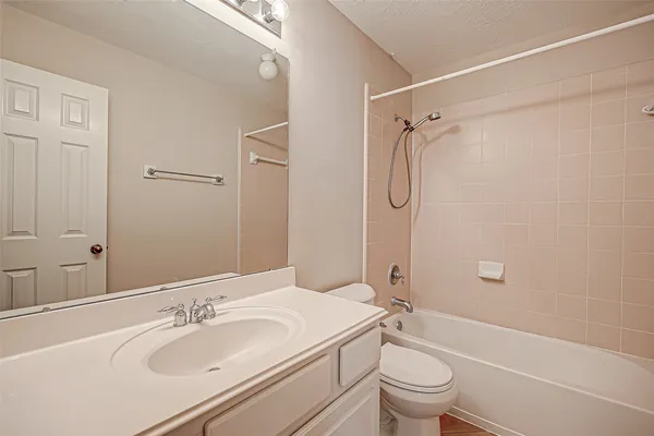a bathroom with a granite countertop sink toilet mirror and shower