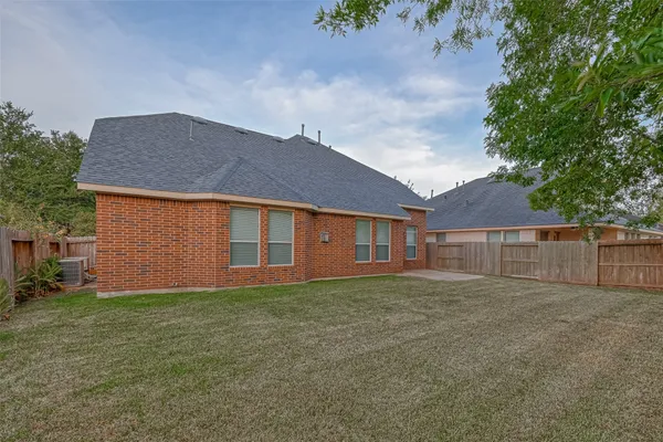 a front view of house with yard and trees in the background