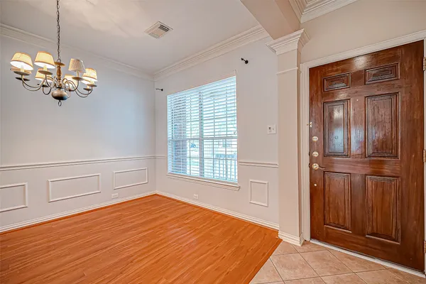 a view of a livingroom with a chandelier fan and windows