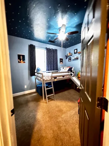 a spacious bedroom with a bed and a chandelier