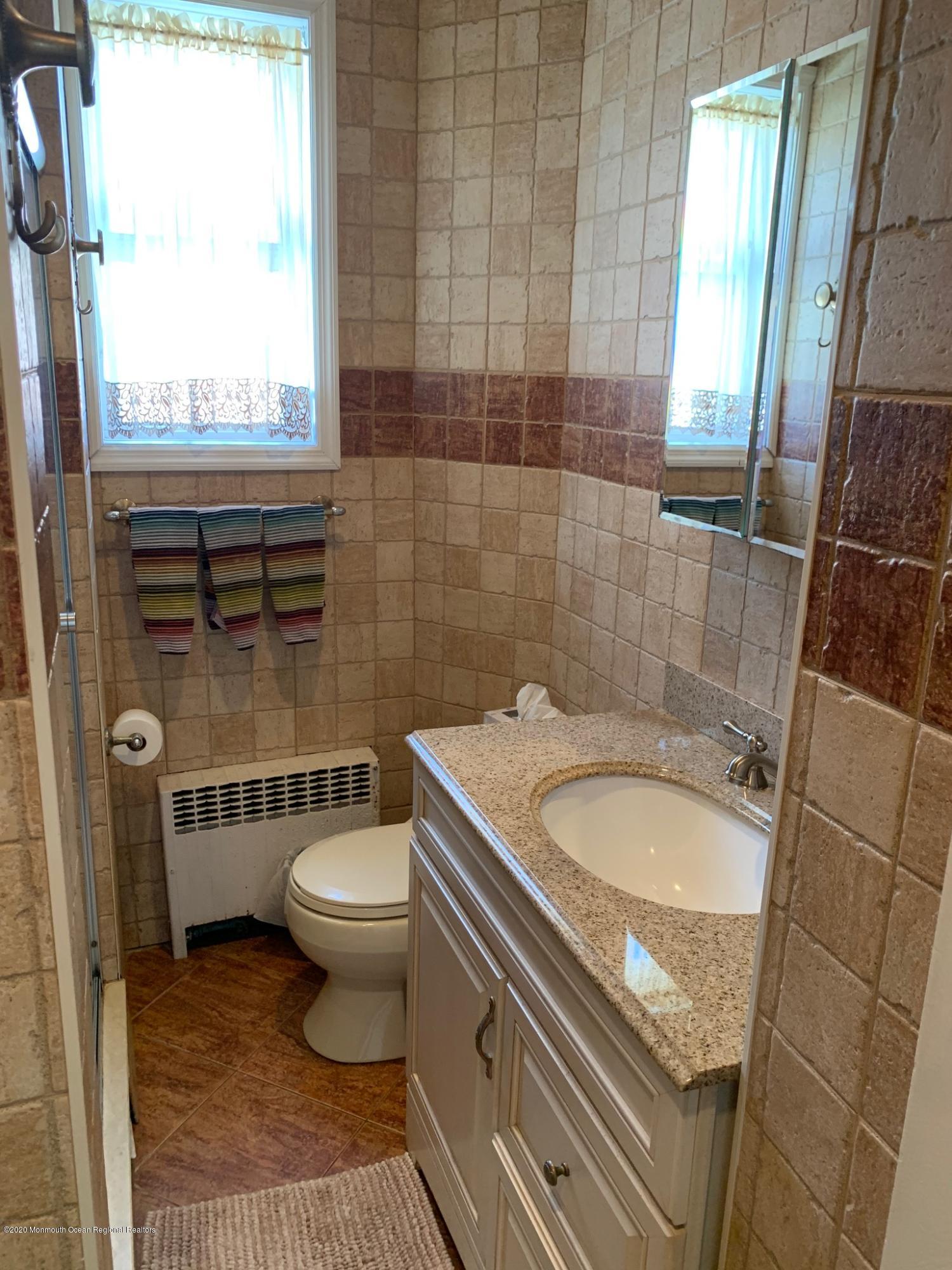 9 Wyckoff Street Deal, NJ 07723 - Photo 7 of 15 a bathroom with a granite countertop toilet a sink and a shower