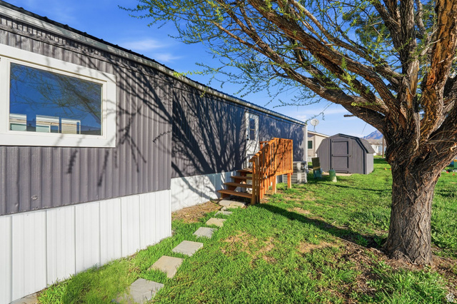 2491 Highway 89, Unit 523 Pleasant View, UT 84404 - Photo 20 of 31 View of green lawn with a storage shed