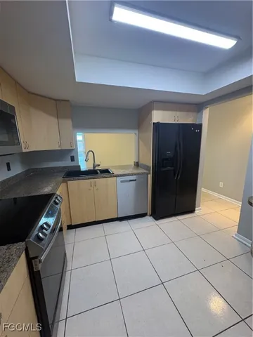 a kitchen with stainless steel appliances granite countertop a refrigerator and a stove top oven