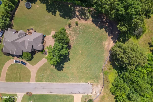 an aerial view of a house with a yard and lake view