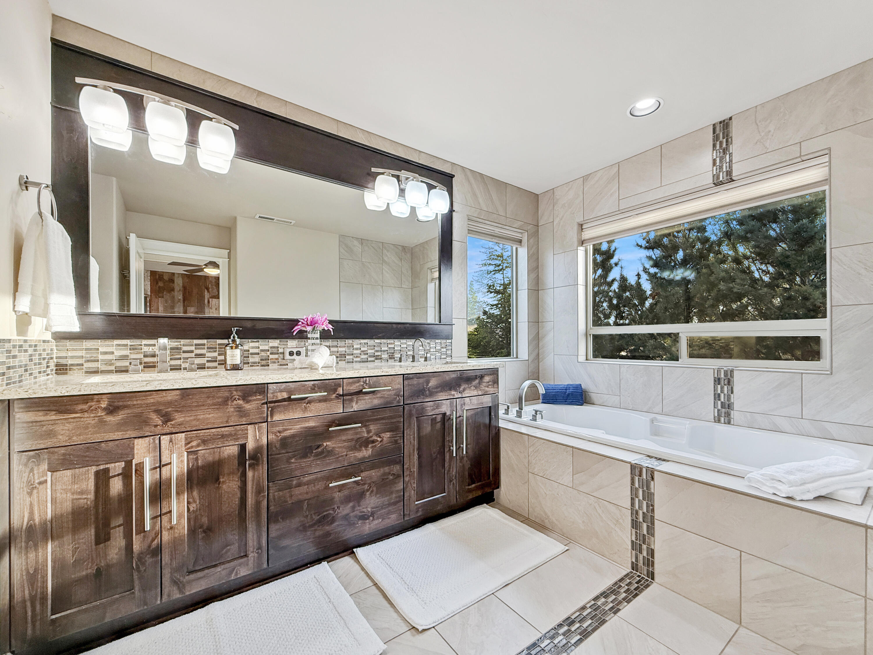 61072 Manhae Loop Bend, OR 97702 - Photo 23 of 63 a bathroom with a sink mirror and a bathtub next to a window