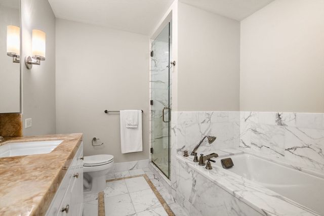 a bathroom with a granite countertop sink a toilet and shower