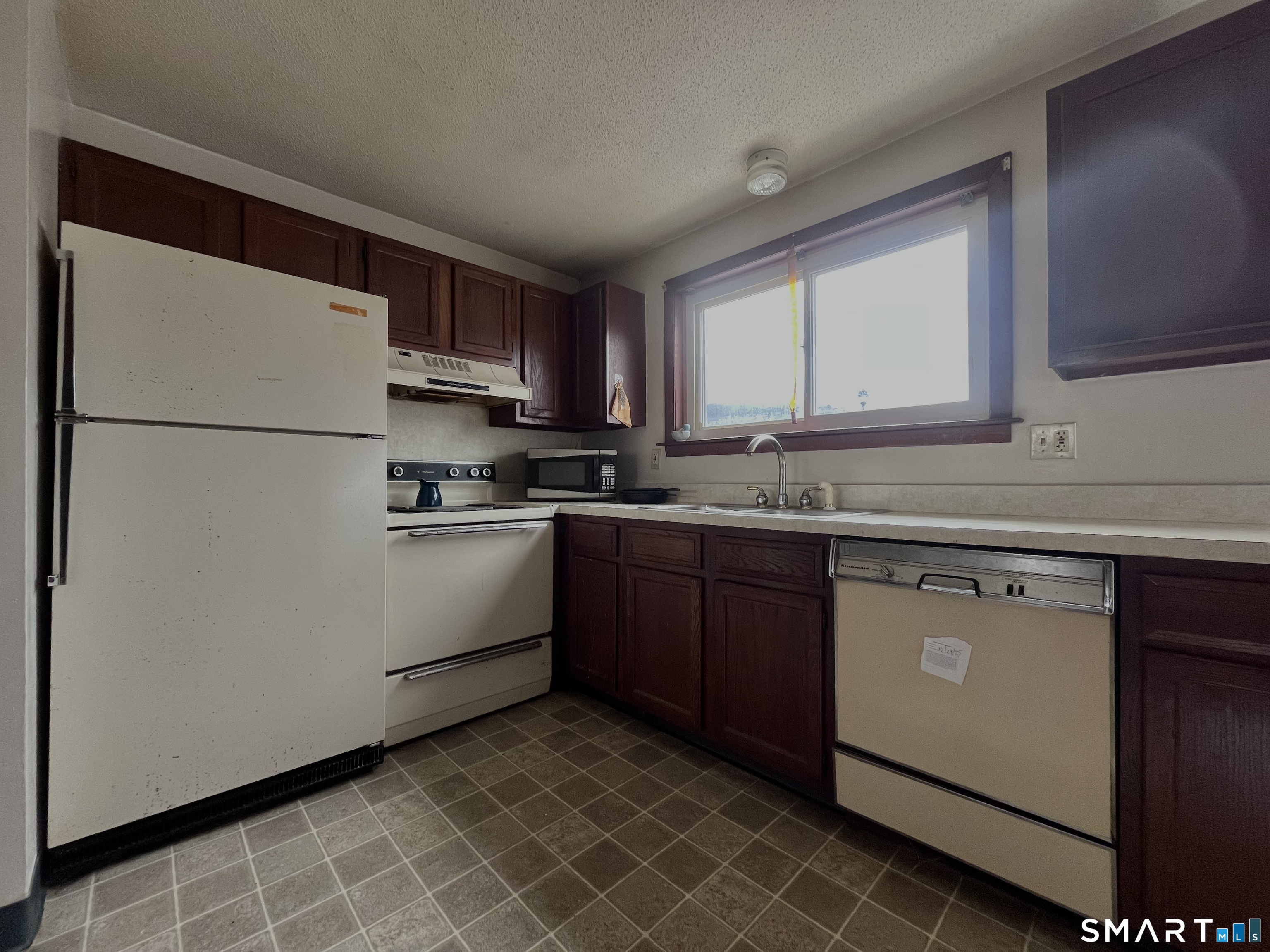 1081 New Haven Road, Unit 11J Naugatuck, CT 06770 - Photo 4 of 17 a kitchen with a sink a refrigerator and cabinets