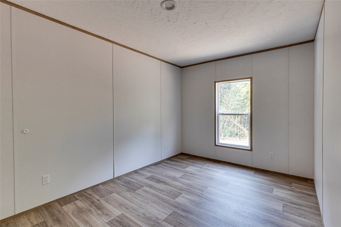 474 Bryant Road Pelzer, SC 29669 - Photo 38 of 42 Wood-look vinyl plank flooring and ample natural light fill this inviting bedroom space.