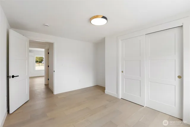 an empty room with closet and mirror