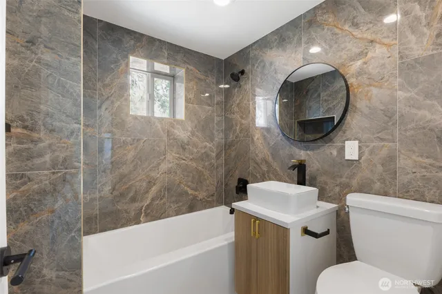 a white toilet sitting next to a bath tub