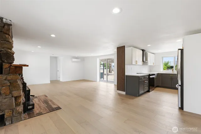 a large white kitchen with a refrigerator a sink dishwasher and a stove with wooden floor