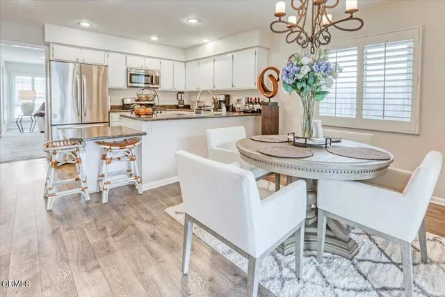 a dining room with furniture a chandelier and kitchen view