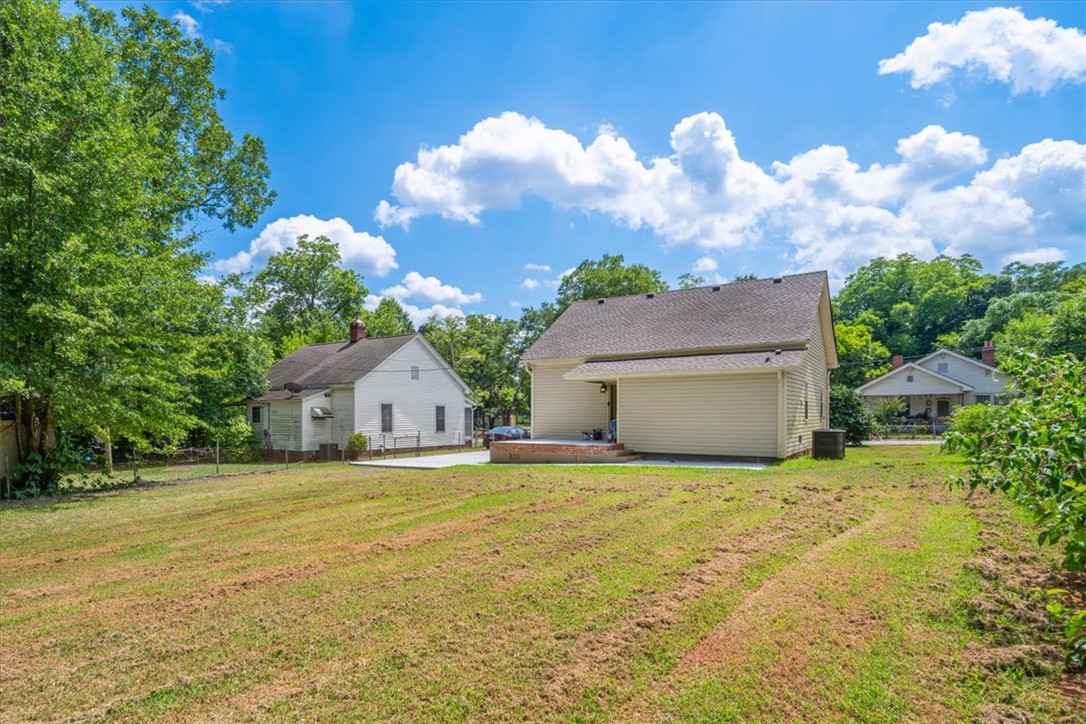 1102 West End Avenue Anderson, SC 29625 - Photo 25 of 28 A spacious backyard with two residential structures and vibrant mature trees.