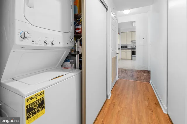 a view of washer and dryer with bathroom in the background