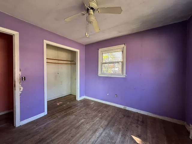 an empty room with a ceiling fan and windows