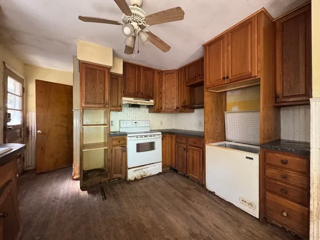 a kitchen with kitchen island granite countertop wooden floors white cabinets and stainless steel appliances