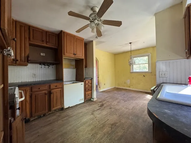 a kitchen with granite countertop a stove cabinets and a wooden floor